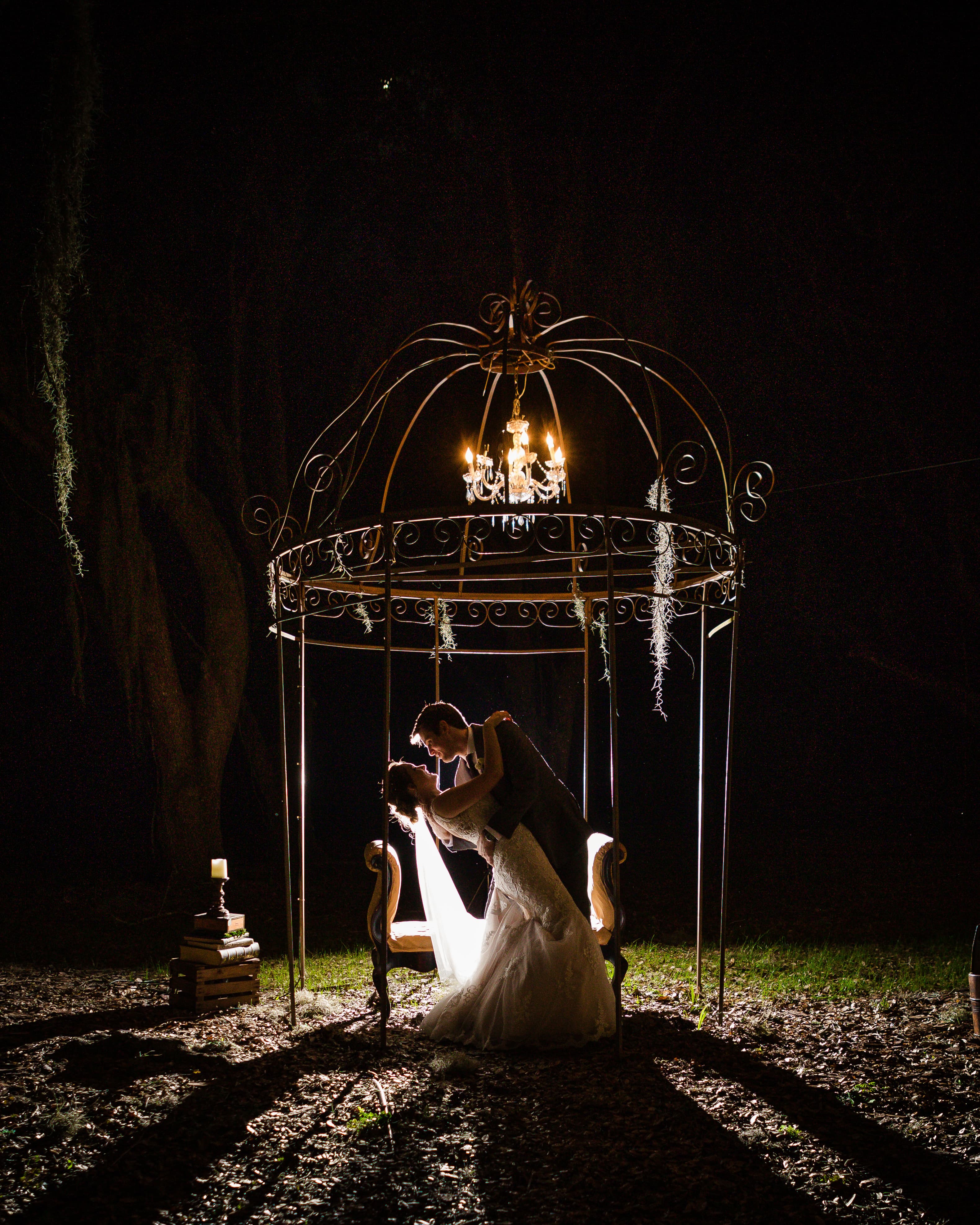Bride under the barn's string-lit gable at Chapel Creek